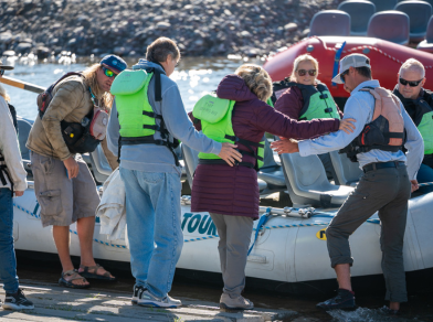 guide helping patrons on teton scenic float tours